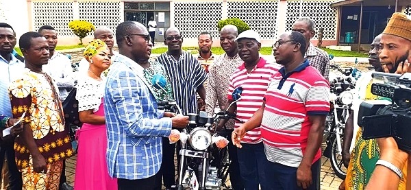 Mr Seth Oduro-Boadu, the MCE (left) presenting one of the motorbikes to an assembly member while others wait for their turn Mr Seth Oduro-Boadu, the MCE (left) presenting one of the motorbikes to an assembly member while others wait for their turn