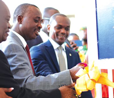 Mr Yaw Adom Boateng (in blue suit), MD of NSIA Insurance being supported by Mr Kofi Andoh (in grey suit), Deputy Commissioner, NIC, as well as Mr K. T. Dadzie, board member, NSIA Insurance cutting the tape to officially open the new office. 