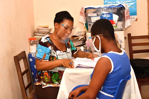 Ms Margaret M. Avadzi, the SHEP Coordinator of the Atua St Paul’s Presby Basic School attending to a sick student. JICA supports schools in Lower Manya Krobo Municipality