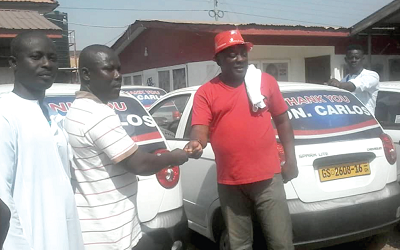Mr Kingsley Carlos Ahenkorah (right), MP for Tema West, handing over the keys of one of the cars to Mr Isaac Kwarteng, one of the beneficiaries