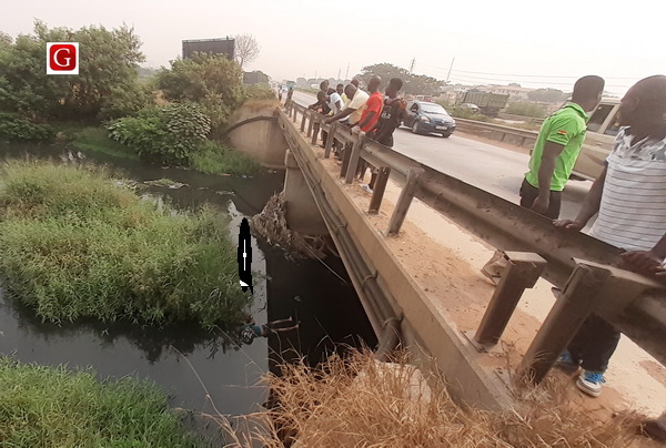 The dead man (arrowed) lying in the drain at Ashaiman The dead man (arrowed) lying in the drain at Ashaiman