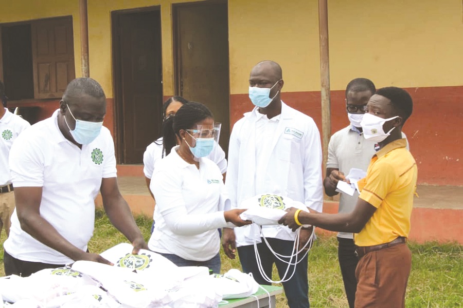 • Ms Akua Sakyi, Corporate Affairs Manager of the Bui Power Authority, presenting a package containing books, a math set, pens, pencils, among others to Michael Kumah, a student of the school. Staff of Bui Power Authority assist students