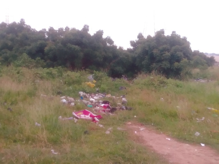 Refuse scattered on the playground. Playground at Kanawu still dumping site