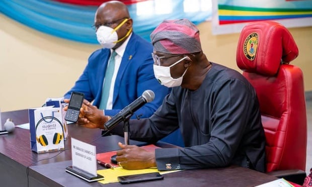Adesola Adeduntan, left, CEO of First Bank of Nigeria, which part-funded the mobile phones, with the governor of Lagos, Babajide Sanwo-Olu. Lagos distributes free phones to pupils; To bridge digital divide