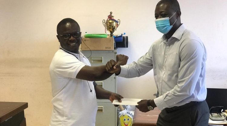 Mr Seth Nti(left) Secretary General of the GSA presenting a stimulus package to father of Papa Yaw Poku-Dwumoh Five swimmers receive COVID-19 financial support