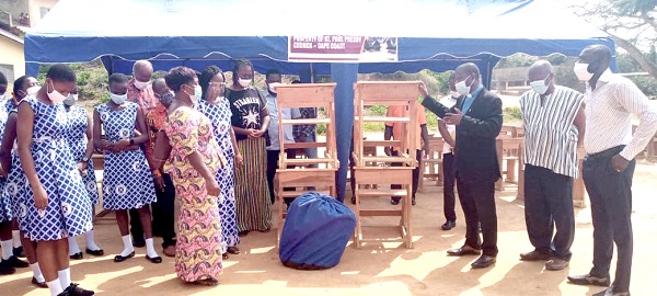Rev Benjamin Ofori Twum (third right), presenting the items to the school. Mono desks and canopies for Cape Coast Presbyterian Basic School