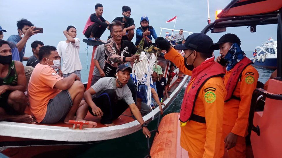 Local fishermen retrieve suspected debris and hand it to search and rescue teams Local fishermen retrieve suspected debris and hand it to search and rescue teams