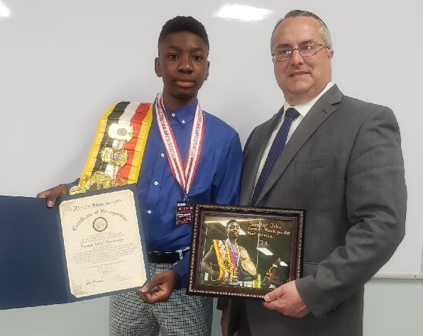 Joseph Awinongya Jnr (left) receiving the certificate of recognition from Senator John R. Connor