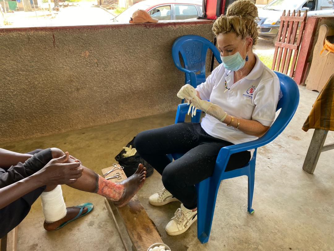 A foreign volunteer dressing the wound of a cured lepe A foreign volunteer dressing the wound of a cured lepe
