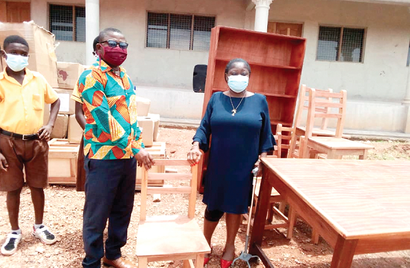 Seth Amissah (2nd left), the headmaster of the D/A JHS, Manso Adubia, receiving the library items from Madam Genevieve Eba-Polley, the Director of the Ghana Book Trust 