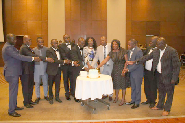 Mr William Adum Addo (6th from left), President of PIWA, cutting the anniversary cake with some members and other players in the pharmaceutical industry 