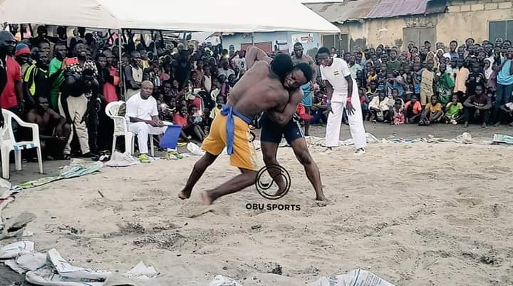 Spectators watch two wrestlers slug it out at the 76kg category National Traditional Wrestling Champs end in Accra