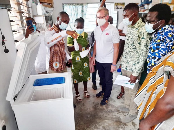 Mr Richard Essien (2nd left), the Kwahu Afram Plains South District Health Director, demonstrating how the vaccine refrigerators powered by the solar energy is aiding the storage of all types of vaccines at the Kwasi Addae CHPS health facility (right picture). With him is Mr Wiesel (4th left), the Project Coordinator of the Green People’s Energy Project of the GIZ Solar panels for 30 CHPS compounds in Afram Plains