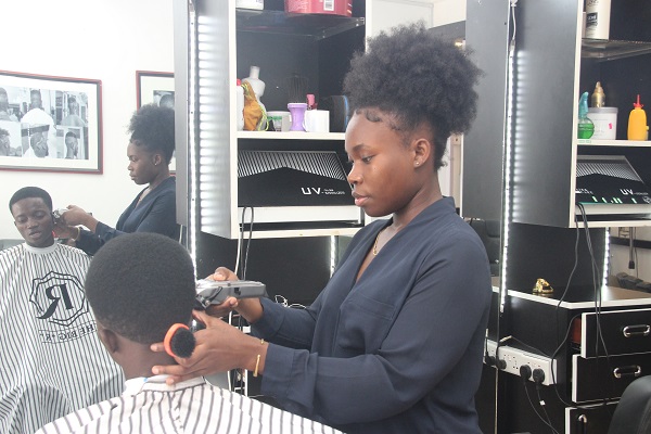 • Miss Botchway trimming a client’s hair Young Legon graduate ventures into barbering