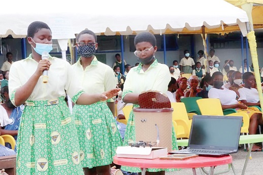 Edinam Agyeman (with mic) explaining how the automatic refuse bin works as her two other mates look on