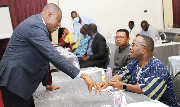 Emmanuel Baidoo (left), Senior Manager, Sustainability  of AngloGold Ashanti Ghana Limited, interacting with Sulemanu Koney (right), CEO of the Ghana Chamber of Mines, at a symposium in Accra. With them is Prof. Dr Lawrence Lowell (2nd from right), Executive Director of Cedi Ghana. Picture: GABRIEL AHIABOR