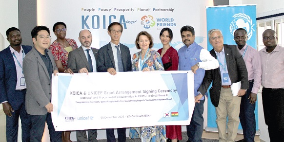Anne-Claire Dufay (arrowed), UNICEF Country Representative, and Moo Heon Kong (3rd from left) holding the signed poster with other officials after the signing Anne-Claire Dufay (arrowed), UNICEF Country Representative, and Moo Heon Kong (3rd from left) holding the signed poster with other officials after the signing