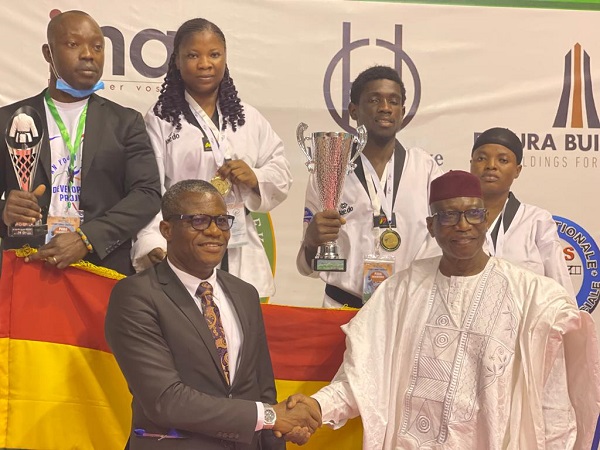 Mr Fredrick Lartey Otu (left) being congratulated by Mr Ide Issaka, President of African Taekwando Union, while the athletes displays their trophies and medals Mr Fredrick Lartey Otu (left) being congratulated by Mr Ide Issaka, President of African Taekwando Union, while the athletes displays their trophies and medals