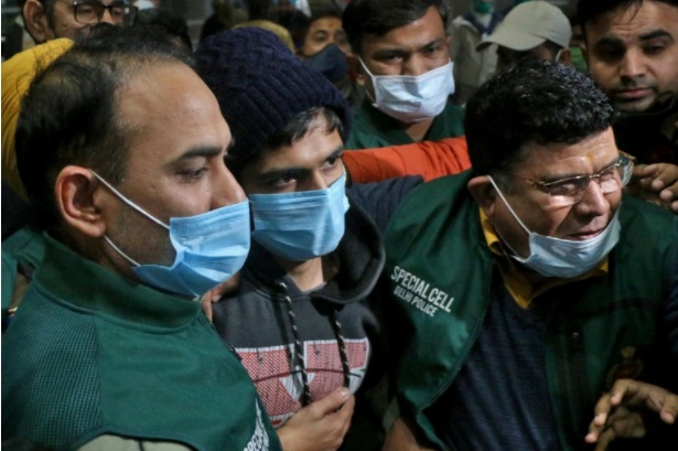 Police officials escort Niraj Bishnoi through New Delhi airport after he was arrested for allegedly creating an online app that shared pictures of Muslim women for a virtual 'auction' [Reuters]