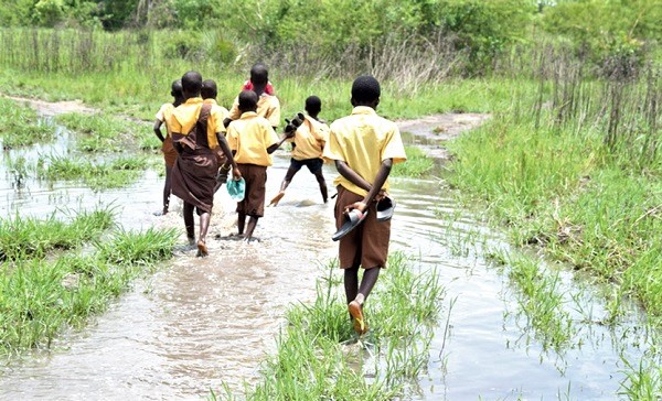 Children from Agortorkpor walking to school at Dzabukpo on a marshy road