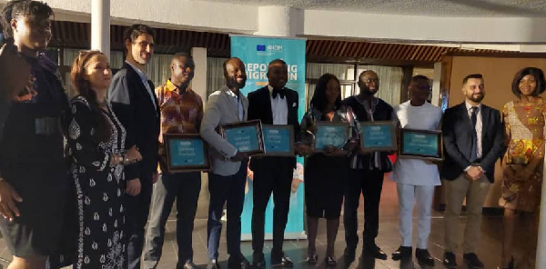 The six journalists who won prizes at the awards ceremony in a group photo with the officials from IOM, EU and the Ministry of Foreign Affairs