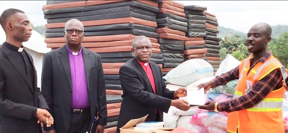 Rt Rev. P.S. Dzomeku, Moderator of GEC, presenting the items to Mr Louis Afful, Deputy Municipal NADMO Director Rt Rev. P.S. Dzomeku, Moderator of GEC, presenting the items to Mr Louis Afful, Deputy Municipal NADMO Director