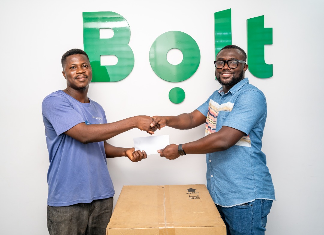 Henry Whyte (right), Senior Operations Manager, Bolt Ghana presenting a 4-burner gas cooker and a cash prize to Philip Mensah. Bolt
