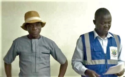 Aguri Haruna Abdul Rahim, an official of the electoral commission, declaring the result while Joseph Mbugri (left) looks on Aguri Haruna Abdul Rahim, an official of the electoral commission, declaring the result while Joseph Mbugri (left) looks on