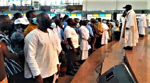 Very Rev. Fr. Edmund Donkor-Baine (with mic) praying for the men while his assistant sprinkles holy water on them Very Rev. Fr. Edmund Donkor-Baine (with mic) praying for the men while his assistant sprinkles holy water on them