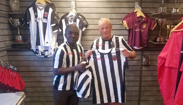 Sampson Osei Yaw (left) receiving the jerseys from Jon Watkinson, General Manager of Chorley FC