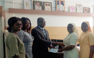 Dwomoh-Ameyaw (3rd from left) presenting the cheque to Theresa Authur Dwomoh-Ameyaw (3rd from left) presenting the cheque to Theresa Authur