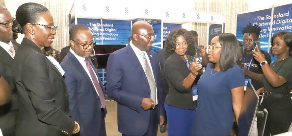 Tracy Oppong-Manu (2nd from right), Founder of the Simpliexpand digital platform, explaining a point about her product to Vice-President Dr Mahamudu Bawumia (3rd from left), during an exhibition mounted at the Standard Chartered Digital Banking Innovation and Fintech Festival in Accra. Those in the picture include Dr Maxwell Opoku-Afari (2nd from left), the First Deputy Governor of the Bank of Ghana, and Mansa Nattey (left), Chief Executive Officer of the Standard Chartered Bank. Picture: GABRIEL AHIABOR Tracy Oppong-Manu (2nd from right), Founder of the Simpliexpand digital platform, explaining a point about her product to Vice-President Dr Mahamudu Bawumia (3rd from left), during an exhibition mounted at the Standard Chartered Digital Banking Innovation and Fintech Festival in Accra. Those in the picture include Dr Maxwell Opoku-Afari (2nd from left), the First Deputy Governor of the Bank of Ghana, and Mansa Nattey (left), Chief Executive Officer of the Standard Chartered Bank. Picture: GABRIEL AHIABOR