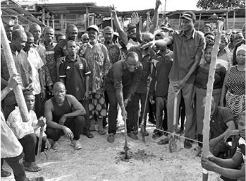 Bismark Tetteh Nyarko (with pickaxe), MP for Upper Manya Krobo Constituency, cutting the sod for work to commence. Looking on are some residents of Sekesua Bismark Tetteh Nyarko (with pickaxe), MP for Upper Manya Krobo Constituency, cutting the sod for work to commence. Looking on are some residents of Sekesua
