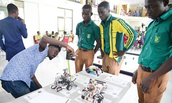 Kojo Anyinam Boateng (left), Executive Judge of the competition, measuring the size of a robot for students of Prempeh College Kojo Anyinam Boateng (left), Executive Judge of the competition, measuring the size of a robot for students of Prempeh College