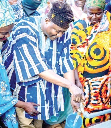 Fawaz Aliu, a Deputy Chief of staff, turning on a tap after the commissioning of the boreholes Fawaz Aliu, a Deputy Chief of staff, turning on a tap after the commissioning of the boreholes