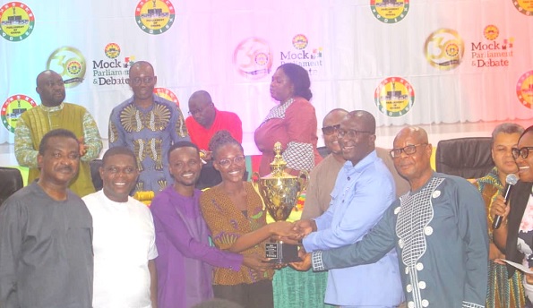 Andrew Asiama Amoako (3rd from right), second Deputy Speaker of Parliament, presenting the trophy to the UCC debate team. With them are some parliamentarians at the programme Andrew Asiama Amoako (3rd from right), second Deputy Speaker of Parliament, presenting the trophy to the UCC debate team. With them are some parliamentarians at the programme