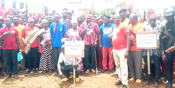 Naba Roland Atogumdeya Akwara III (arrowed) demonstrates at the collapsed bridge with some residents