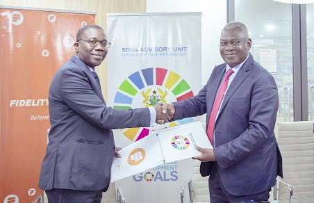 Julian Opuni (left), Managing Director of Fidelity Bank, exchanging the agreement with Dr Ernest Owusu, Presidential Advisor, SDGs Advisory Unit