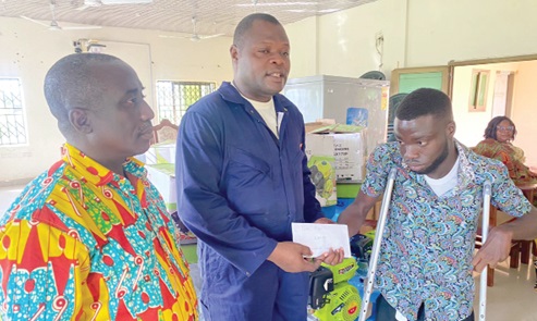 Ernest Victor Apau (middle), Ho West DCE, presenting an amount of money to Isaac Abor, a computer science student of the Ho Technical University, while Roland Kumfo, the District Director of Social Welfare, looks on Ernest Victor Apau (middle), Ho West DCE, presenting an amount of money to Isaac Abor, a computer science student of the Ho Technical University, while Roland Kumfo, the District Director of Social Welfare, looks on