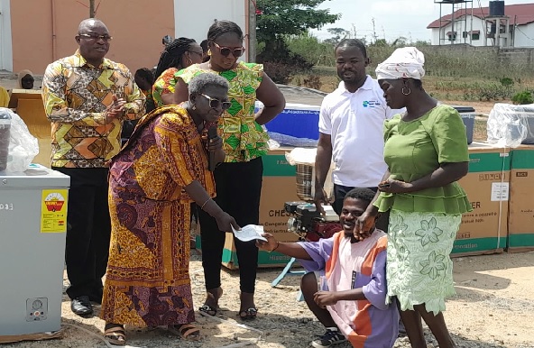 • Comfort Asante (left), Municipal Chief Executive of New Juaben North, presenting a cheque of GH¢1,500 to Tettey Godfred, one of the beneficiaries New Juaben North Assembly distributes start-up kits, cash to PWDs