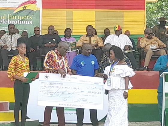 Seth Kwame Acheampong (2nd from left), Eastern Regional Minister, being assisted by Moses Anim, Deputy Minister of Fisheries and Aquaculture Development, to present a cheque of GH¢100,000 to Yaa Ajeley (right), the best female farmer for 2022 17 Years of integrated farming pays off...As Yaa Ajeley is declared Best Female farmer 2022