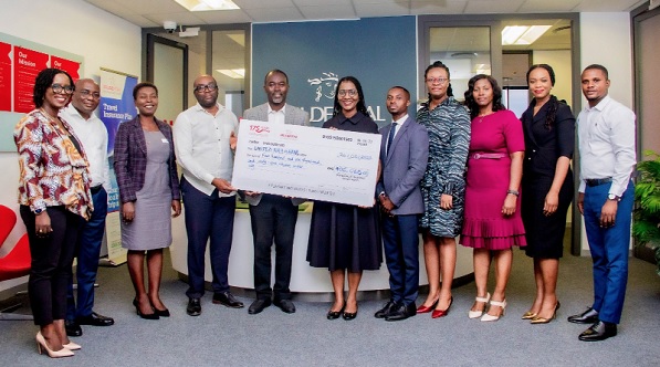 Hazel Berrard Amuah, CEO of Prudential Life Insurance Ghana (5th from left), presenting the dummy cheque to a representative of United Way Ghana, while other senior officials of the company look on