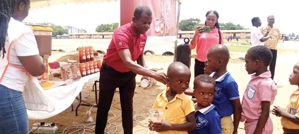 Richard Boafo of the CPC presenting cocoa products to some pupils of Mante Din Basic School in Tema