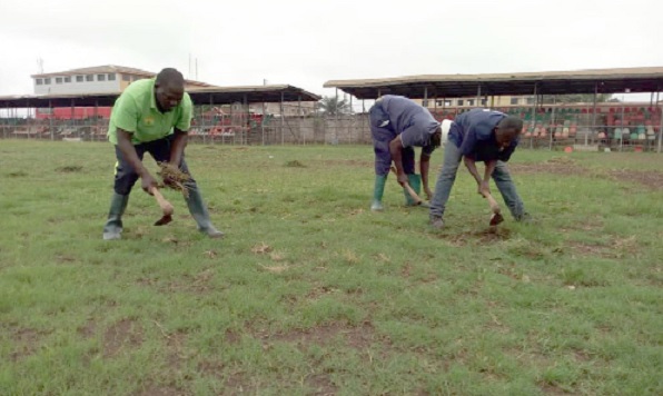 Some fans of Bofoakwa Tano busily uprooting the unwanted grass on the pitch