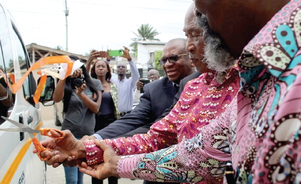 Professor Stephen Adei (right) and Kofi Agamah (in suit) lending a hand to Sam Okudzeto to cut the ribbon to inaugurate the cinema van Professor Stephen Adei (right) and Kofi Agamah (in suit) lending a hand to Sam Okudzeto to cut the ribbon to inaugurate the cinema van