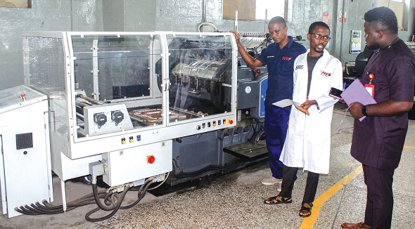 Vincent Kusi-Appiah (middle), Production Manager, G-Pak, explaining a point concerning a die cutting machine to Maclean Kwofi (right), Graphic reporter. Picture: ERNEST KODZI Vincent Kusi-Appiah (middle), Production Manager, G-Pak, explaining a point concerning a die cutting machine to Maclean Kwofi (right), Graphic reporter. Picture: ERNEST KODZI