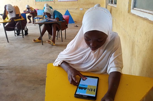 Some of the girls using the app to practise how to read Some of the girls using the app to practise how to read