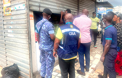 Officials of the Ghana Revenue Authority locking up a business at Maamobi for failing to issue VAT invoice