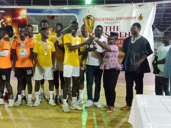 Madam Vivien Nyoni, the PRO of the Ghana Volleyball Association (right) with Mr George Tettey presenting the trophy to El-Wak Wings Captain Eliot Javi