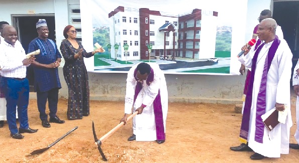 •Rev. John Shadrack Donkoh (with axe), the Bishop of the Evangelical Lutheran Church of Ghana, breaking the ground to start the project while some guests look on •Rev. John Shadrack Donkoh (with axe), the Bishop of the Evangelical Lutheran Church of Ghana, breaking the ground to start the project while some guests look on